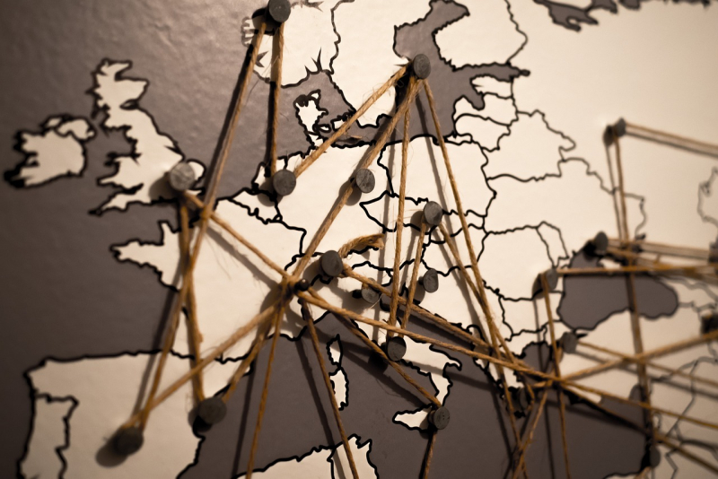 Prácticas MAUC: Ofertas de Prácticas en Servicios Centrales y Representaciones Exterior Foto mapa mundi Europa con puntos unidos por chinchetas e hilos conectados